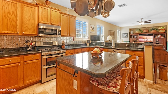 kitchen with visible vents, a sink, appliances with stainless steel finishes, a breakfast bar area, and a peninsula