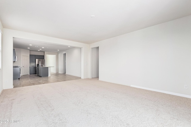 unfurnished living room featuring light carpet