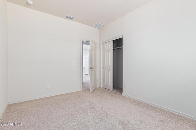 unfurnished bedroom with light carpet and a closet