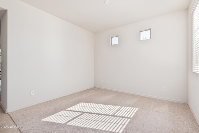 empty room with a wealth of natural light and light colored carpet
