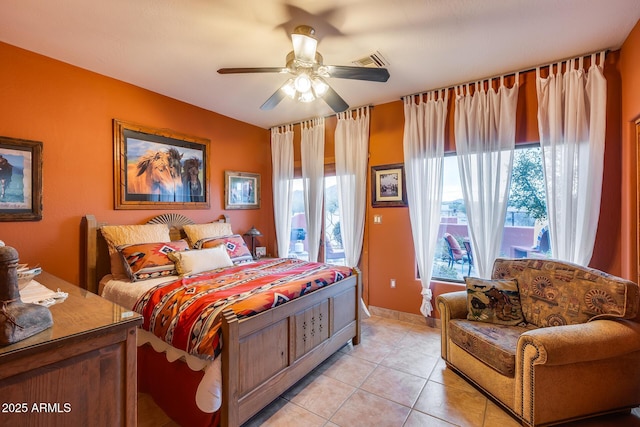 tiled bedroom with ceiling fan and multiple windows