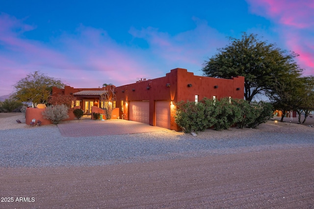 pueblo revival-style home with a garage