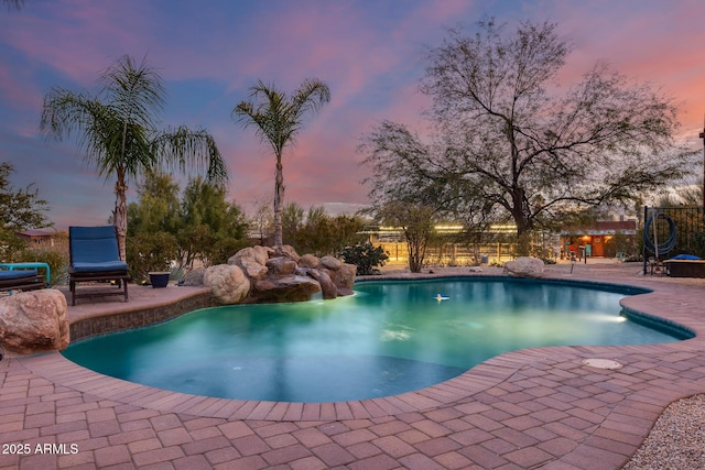 pool at dusk featuring a patio area