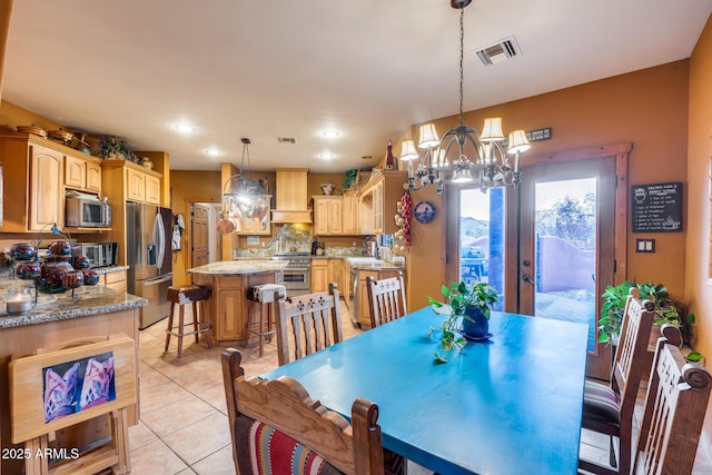 dining area featuring an inviting chandelier, sink, and light tile patterned flooring