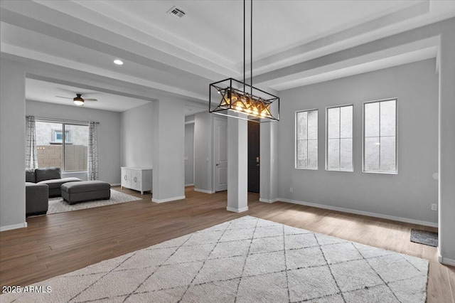 unfurnished dining area featuring visible vents, baseboards, and wood finished floors