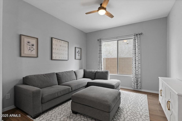 living room with wood finished floors, baseboards, and ceiling fan