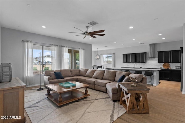 living area featuring visible vents, recessed lighting, light wood-style floors, and a ceiling fan