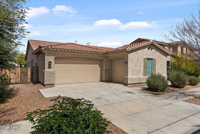 mediterranean / spanish-style home with stucco siding, a tiled roof, concrete driveway, and a garage