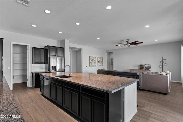 kitchen featuring a ceiling fan, visible vents, stainless steel appliances, a sink, and light wood-style floors