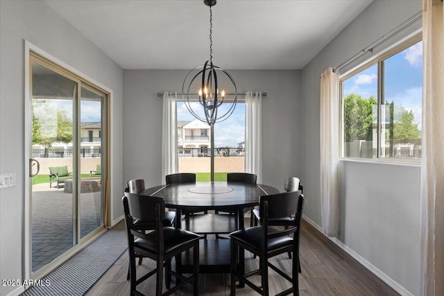 dining room with dark wood finished floors, baseboards, and a chandelier