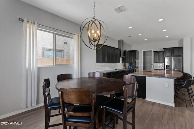 dining room featuring a notable chandelier, visible vents, baseboards, and dark wood-style floors