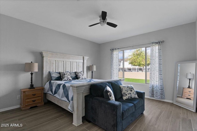 bedroom featuring baseboards, wood finished floors, and a ceiling fan