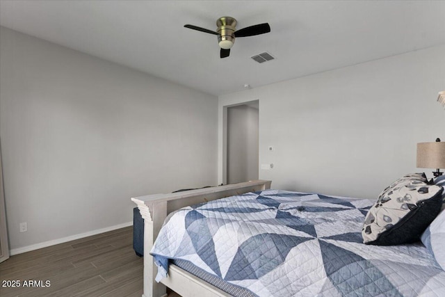 bedroom featuring visible vents, ceiling fan, baseboards, and wood finished floors