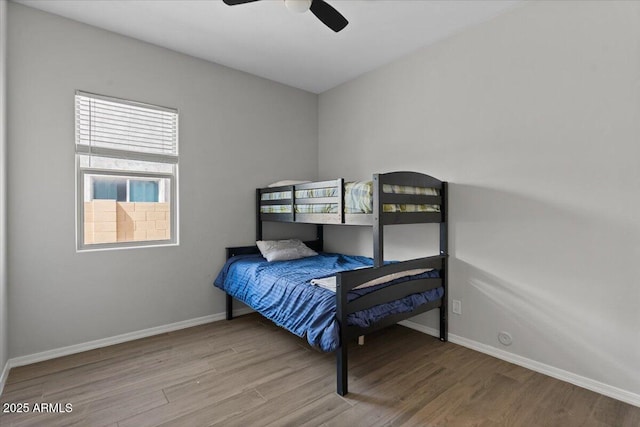 bedroom featuring a ceiling fan, baseboards, and wood finished floors