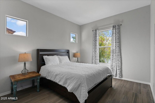 bedroom featuring baseboards and dark wood-style flooring