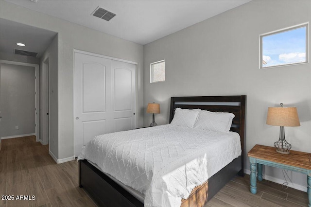 bedroom featuring visible vents, a closet, and wood finished floors