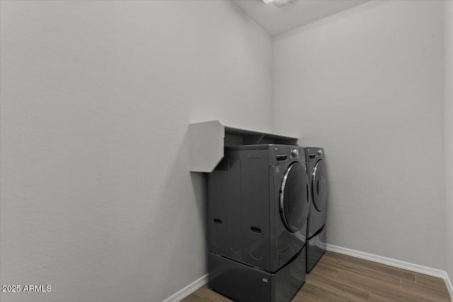 laundry room featuring laundry area, wood finished floors, independent washer and dryer, and baseboards