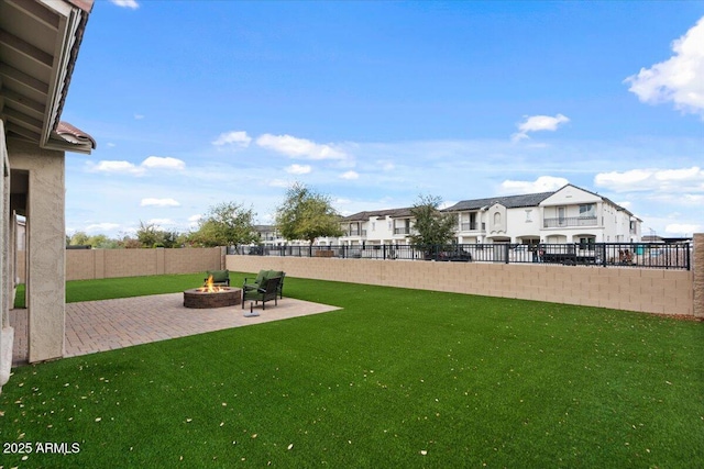 view of yard with a residential view, an outdoor fire pit, a fenced backyard, and a patio area