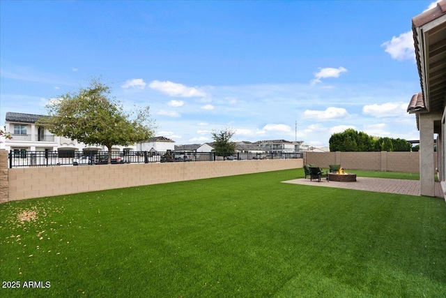 view of yard featuring a patio area, a fenced backyard, and an outdoor fire pit