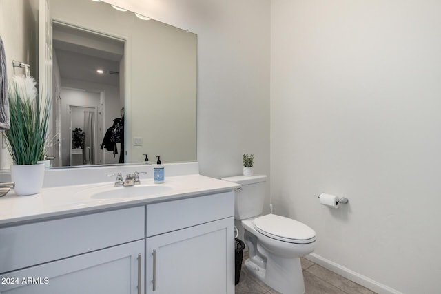 bathroom featuring tile patterned flooring, vanity, and toilet