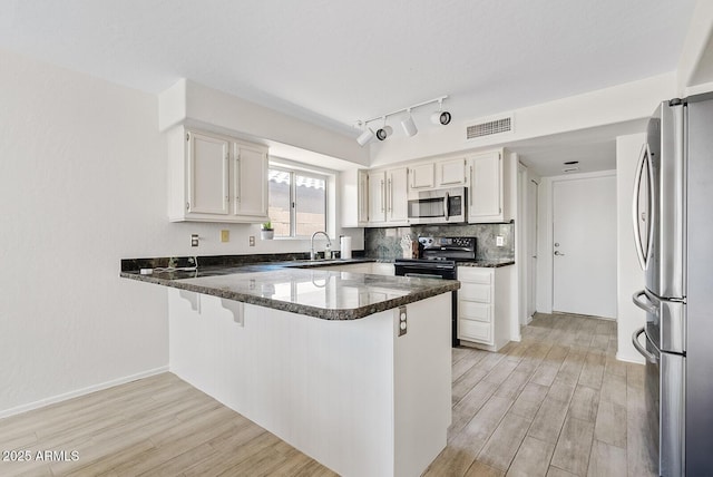 706 N El Dorado Dr, Gilbert, AZ 85233 - kitchen featuring stainless steel appliances, a peninsula, a sink, and light wood-style floors