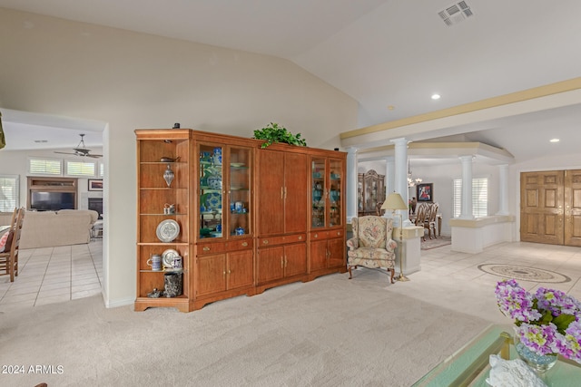 interior space featuring vaulted ceiling, ceiling fan, light colored carpet, and ornate columns