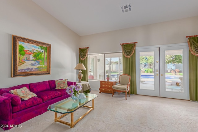 living room featuring french doors, carpet floors, lofted ceiling, and a healthy amount of sunlight