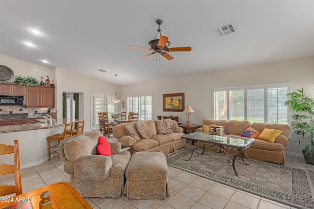 tiled living room featuring lofted ceiling, sink, ceiling fan, and a wealth of natural light