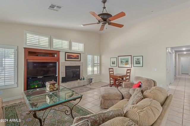 living room with high vaulted ceiling, ceiling fan, light tile patterned flooring, and a fireplace