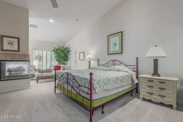 bedroom with high vaulted ceiling, a multi sided fireplace, ceiling fan, and light colored carpet