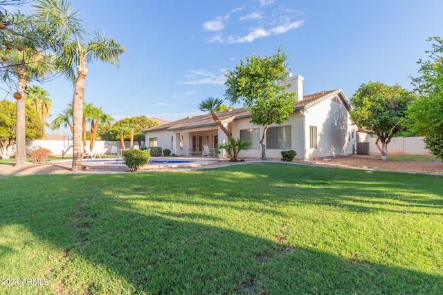 rear view of house featuring a lawn and a patio area