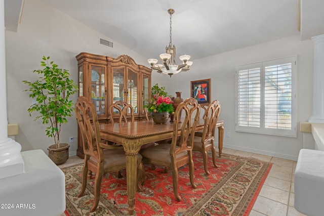 dining space featuring light tile patterned floors, lofted ceiling, and a chandelier