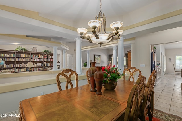 dining space featuring decorative columns, a chandelier, and tile patterned flooring