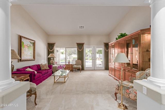 living room with vaulted ceiling, light carpet, french doors, and ornate columns