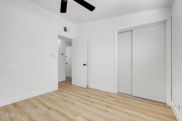 unfurnished bedroom with light hardwood / wood-style flooring, a closet, and ceiling fan