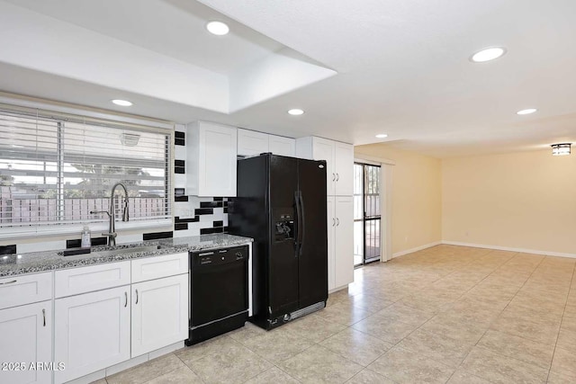 kitchen with recessed lighting, stone countertops, white cabinets, a sink, and black appliances