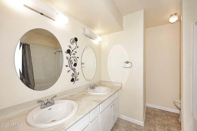 bathroom featuring double vanity, tile patterned flooring, baseboards, and a sink