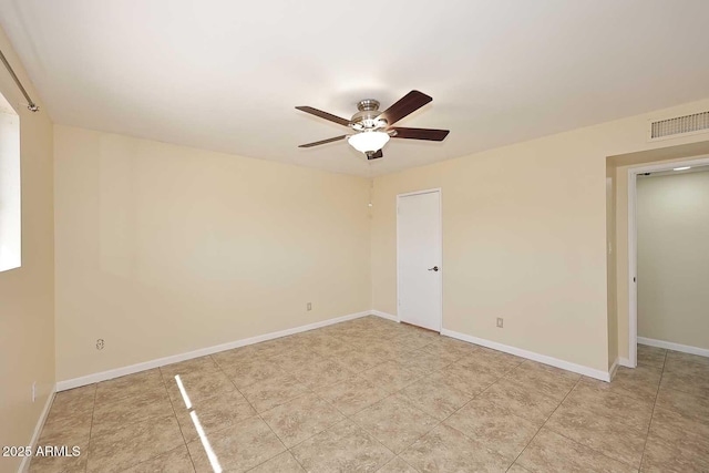 spare room with a ceiling fan, visible vents, and baseboards