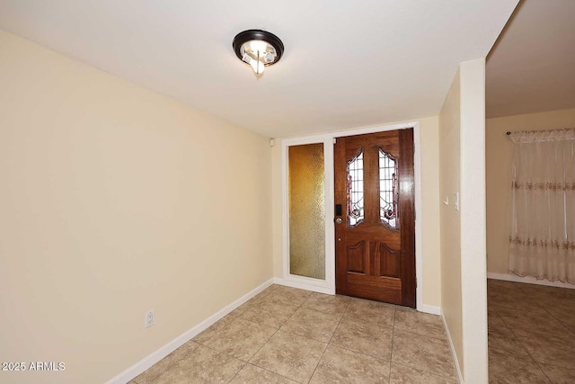 entrance foyer with light tile patterned flooring and baseboards