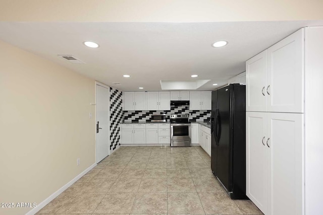 kitchen with visible vents, decorative backsplash, stainless steel electric range, under cabinet range hood, and black fridge