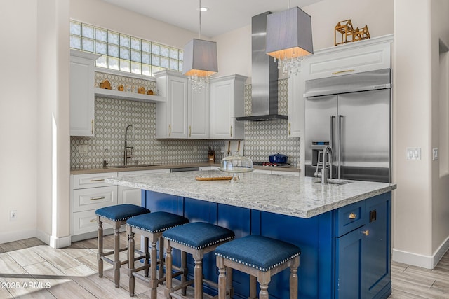 13621 E Aster Dr, Scottsdale, AZ 85259 - kitchen with wall chimney range hood, backsplash, a sink, and built in fridge