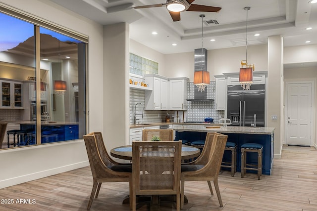 13621 E Aster Dr, Scottsdale, AZ 85259 - dining area featuring a tray ceiling, light wood-type flooring, visible vents, and ceiling fan