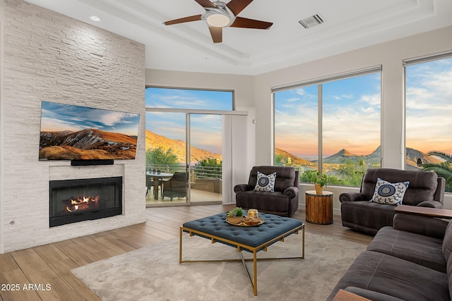 13621 E Aster Dr, Scottsdale, AZ 85259 - living room featuring wood finished floors, a tray ceiling, ceiling fan, and visible vents