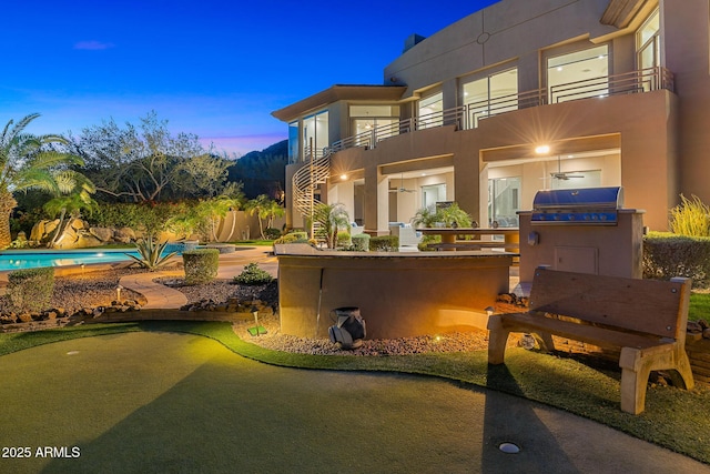 13621 E Aster Dr, Scottsdale, AZ 85259 - patio terrace at dusk with a balcony, area for grilling, stairway, and a fenced in pool