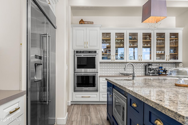 13621 E Aster Dr, Scottsdale, AZ 85259 - kitchen with a sink, white cabinetry, decorative backsplash, and appliances with stainless steel finishes