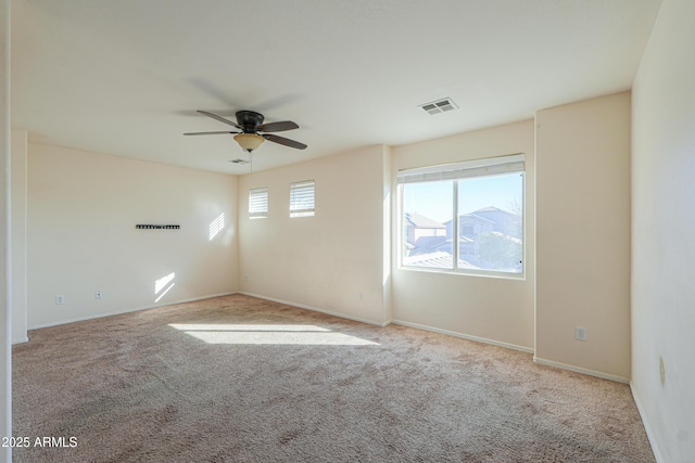 unfurnished room featuring light carpet, ceiling fan, visible vents, and baseboards