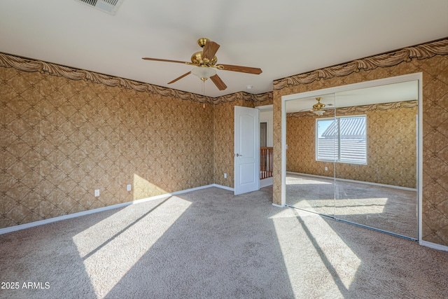 unfurnished room with carpet floors, wallpapered walls, and visible vents