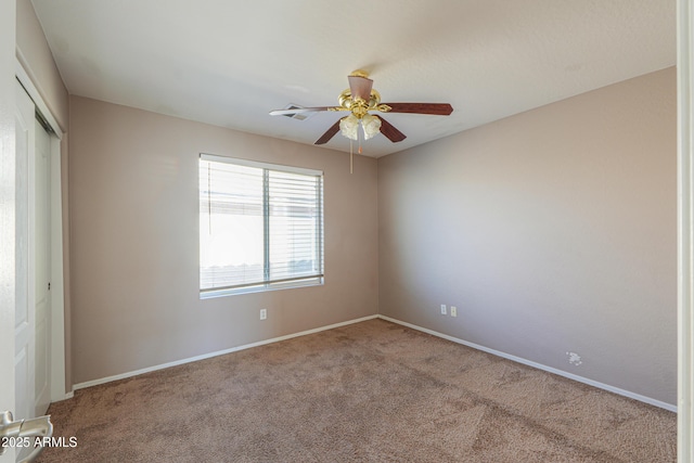 unfurnished room with carpet floors, baseboards, and a ceiling fan