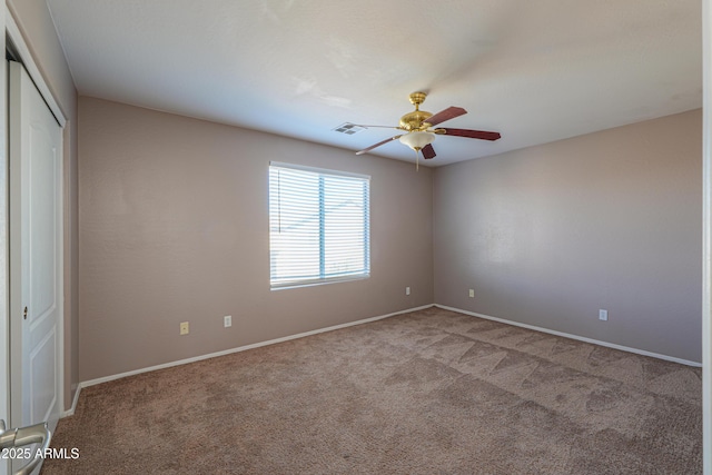 unfurnished bedroom featuring light colored carpet, a ceiling fan, baseboards, visible vents, and a closet