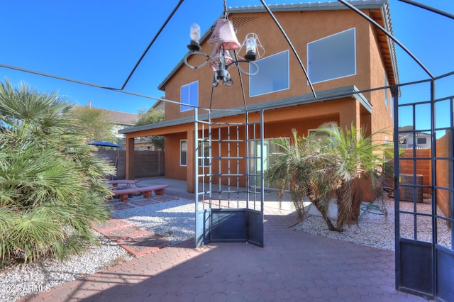 back of house with central air condition unit, a patio area, fence, and stucco siding